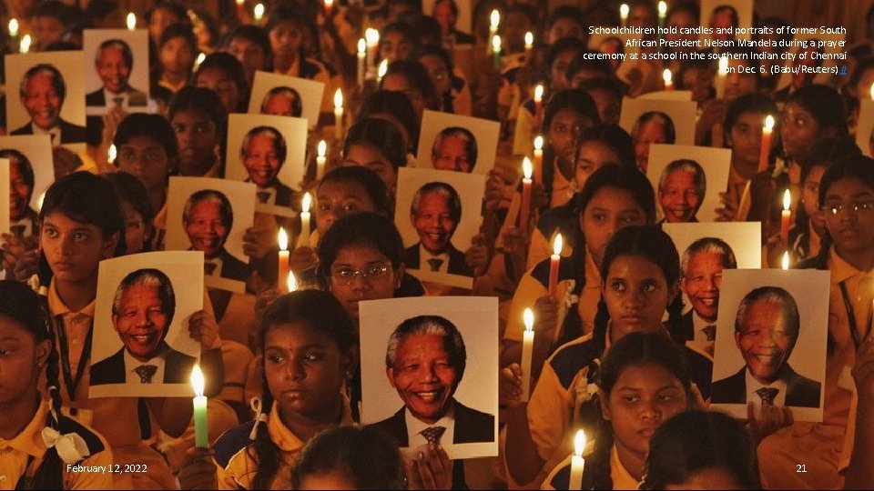 Schoolchildren hold candles and portraits of former South African President Nelson Mandela during a