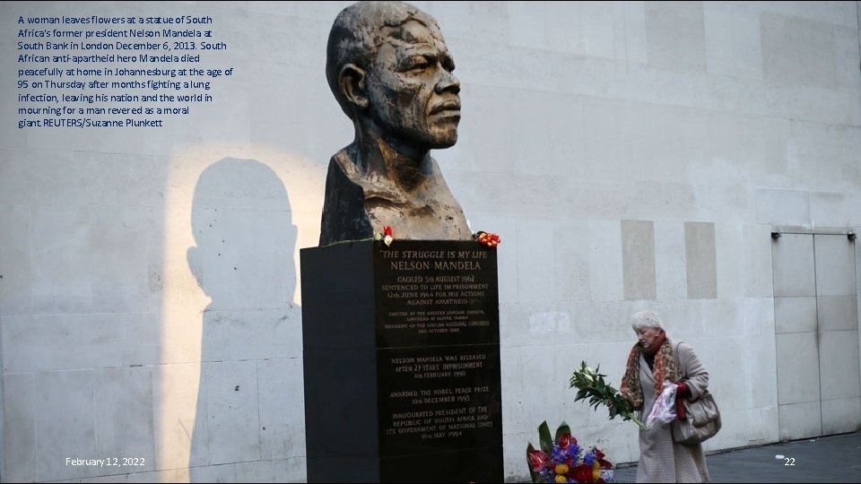 A woman leaves flowers at a statue of South Africa's former president Nelson Mandela