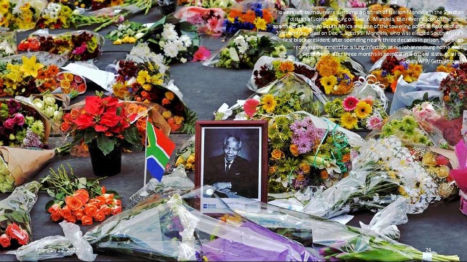 Flowers left by mourners surround a portrait of Nelson Mandela in the Sandton district