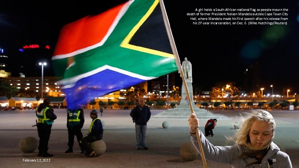 A girl holds a South African national flag as people mourn the death of