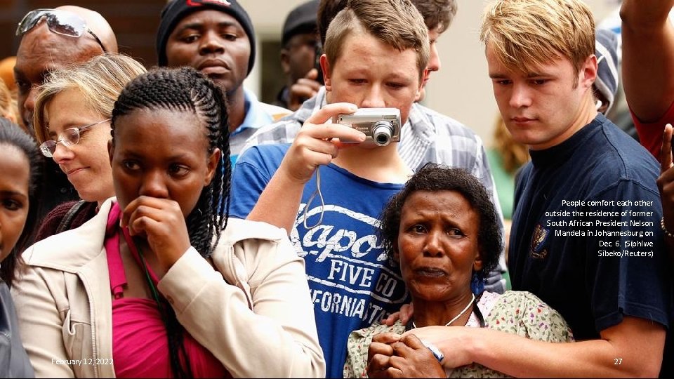 People comfort each other outside the residence of former South African President Nelson Mandela