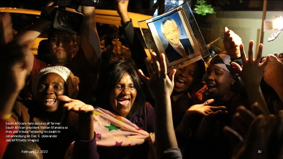 South Africans hold pictures of former South African president Nelson Mandela as they pay