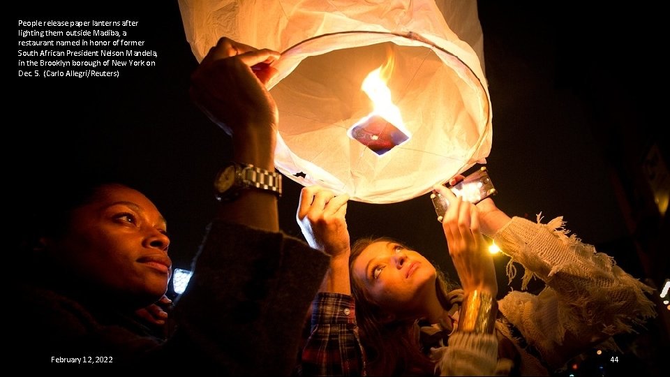 People release paper lanterns after lighting them outside Madiba, a restaurant named in honor