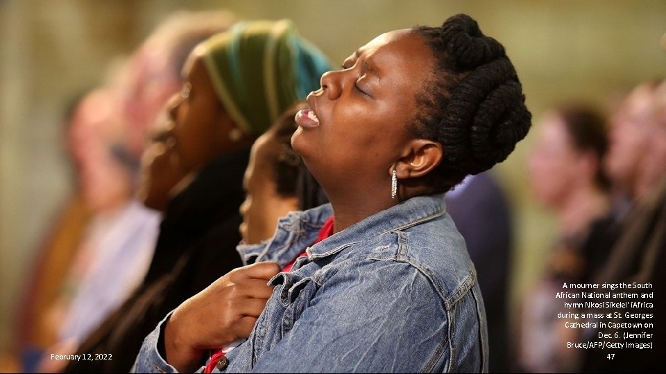 February 12, 2022 A mourner sings the South African National anthem and hymn Nkosi