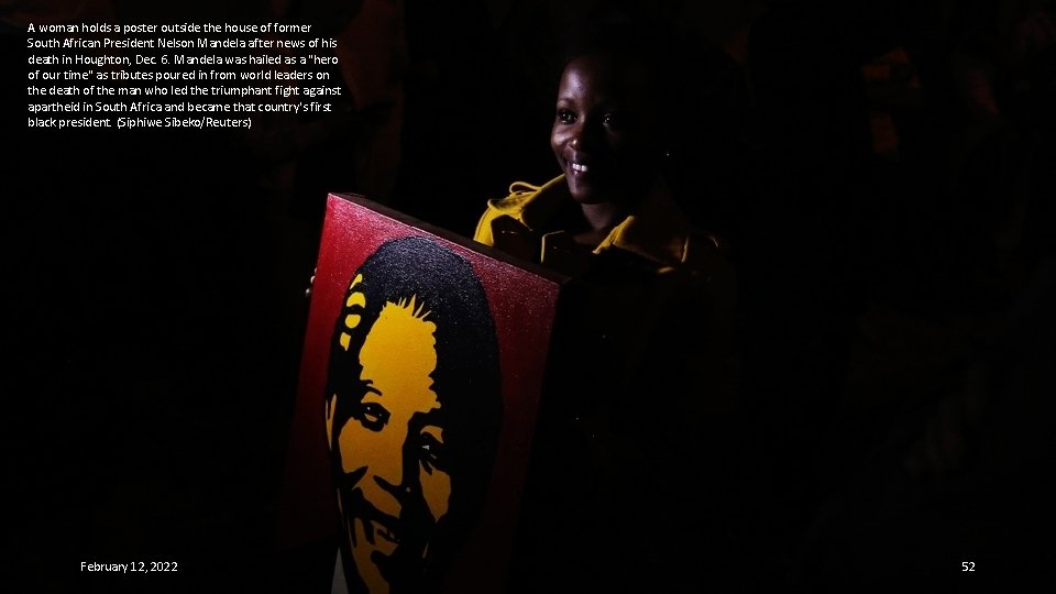 A woman holds a poster outside the house of former South African President Nelson