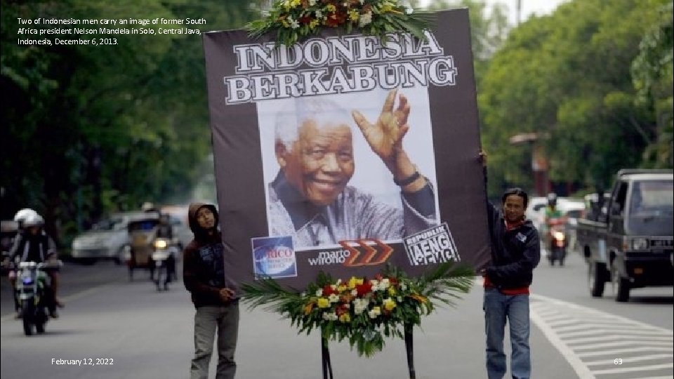 Two of Indonesian men carry an image of former South Africa president Nelson Mandela