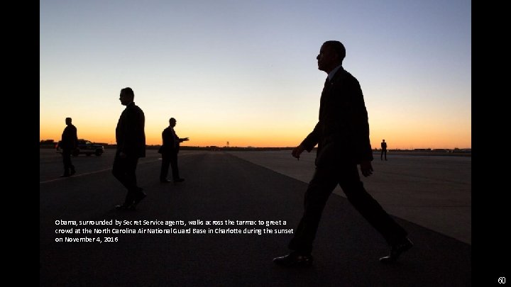 Obama, surrounded by Secret Service agents, walks across the tarmac to greet a crowd