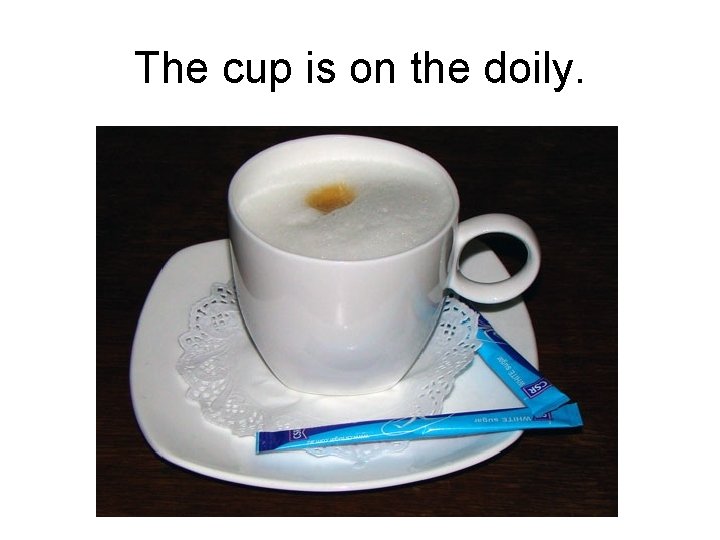 The cup is on the doily. 