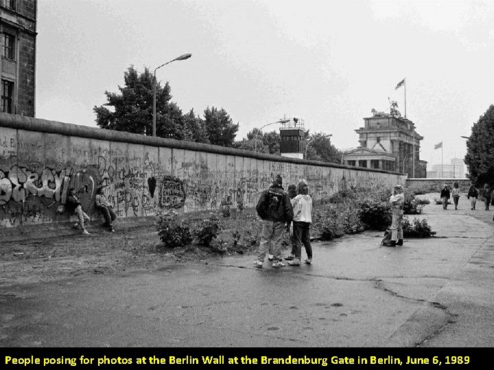 People posing for photos at the Berlin Wall at the Brandenburg Gate in Berlin,