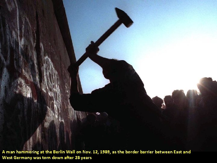 A man hammering at the Berlin Wall on Nov. 12, 1989, as the border