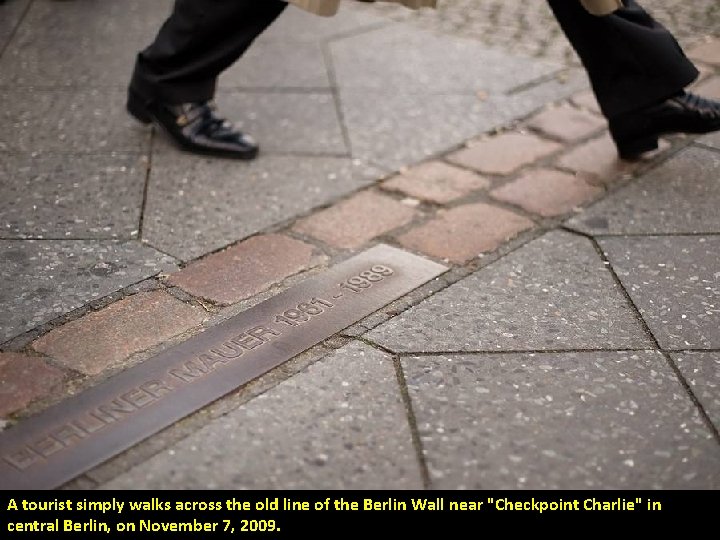 A tourist simply walks across the old line of the Berlin Wall near "Checkpoint