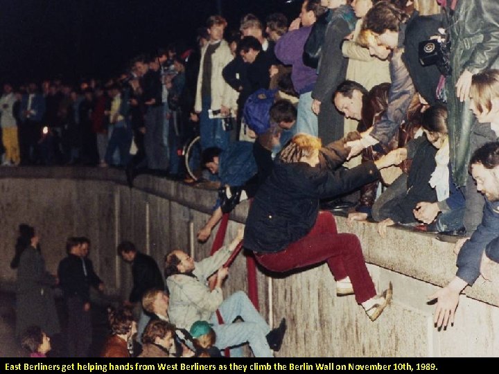 East Berliners get helping hands from West Berliners as they climb the Berlin Wall