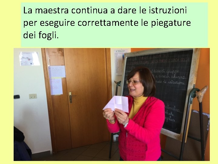 La maestra continua a dare le istruzioni per eseguire correttamente le piegature dei fogli.