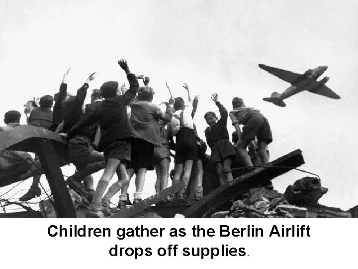 Children gather as the Berlin Airlift drops off supplies. 