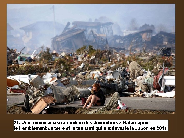 21. Une femme assise au milieu des décombres à Natori après le tremblement de