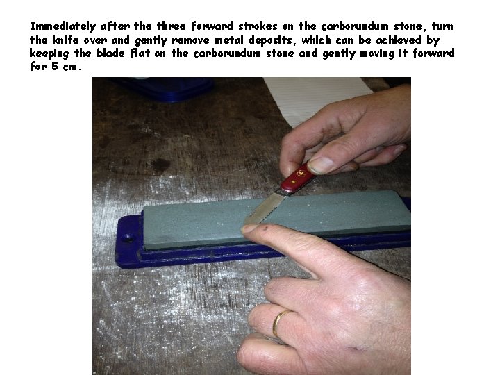 Immediately after the three forward strokes on the carborundum stone, turn the knife over
