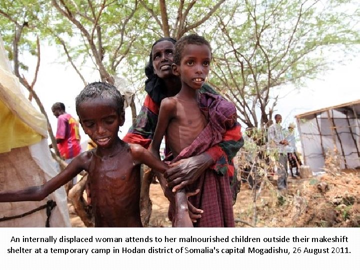 An internally displaced woman attends to her malnourished children outside their makeshift shelter at An internally displaced woman attends to her malnourished children outside their makeshift shelter at