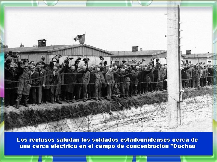 Los reclusos saludan los soldados estadounidenses cerca de una cerca eléctrica en el campo