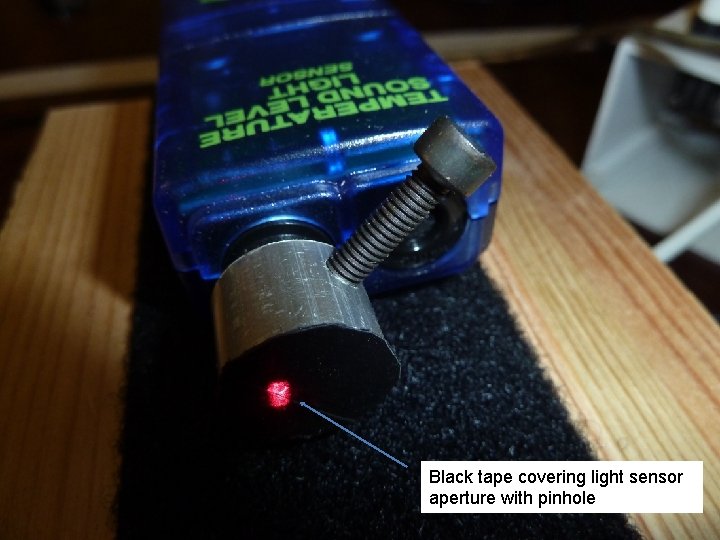 Black tape covering light sensor aperture with pinhole 