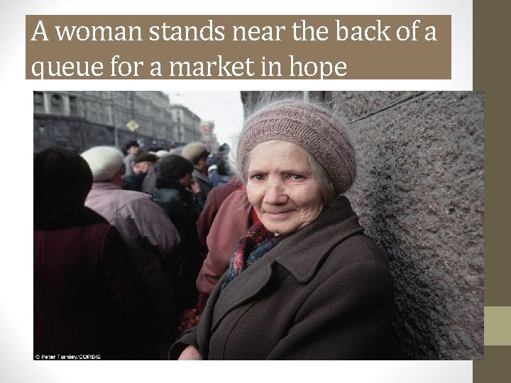 A woman stands near the back of a queue for a market in hope