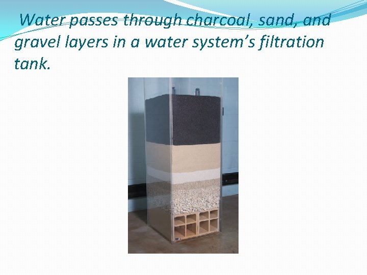 Water passes through charcoal, sand, and gravel layers in a water system’s filtration tank.