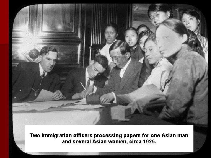 Two immigration officers processing papers for one Asian man and several Asian women, circa