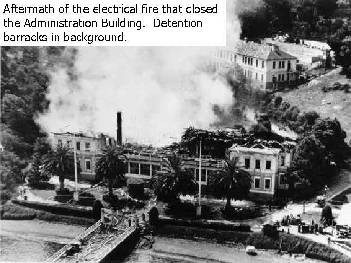 Aftermath of the electrical fire that closed the Administration Building. Detention barracks in background.