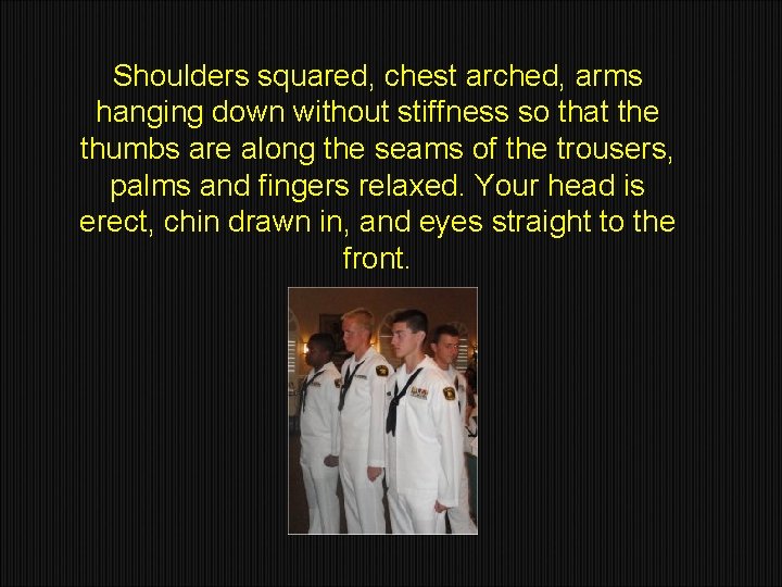 Shoulders squared, chest arched, arms hanging down without stiffness so that the thumbs are