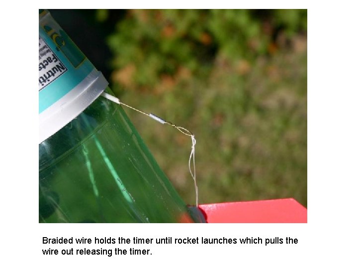 Braided wire holds the timer until rocket launches which pulls the wire out releasing