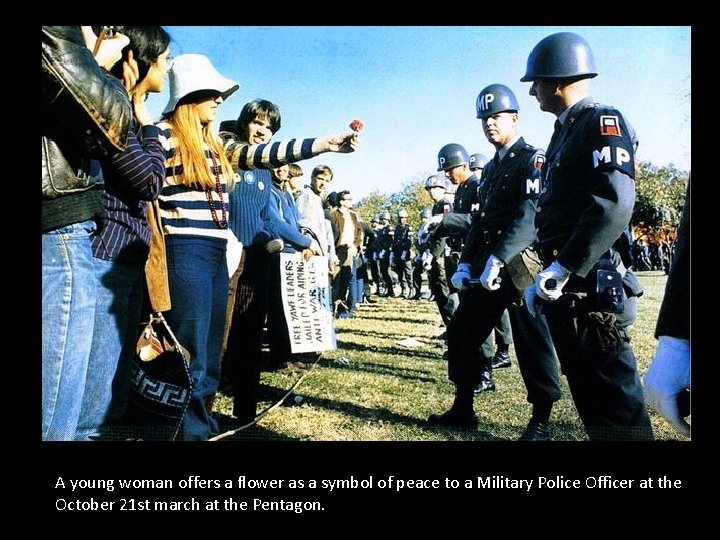 A young woman offers a flower as a symbol of peace to a Military