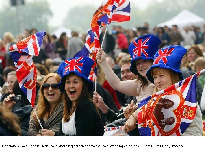 Spectators wave flags in Hyde Park where big screens show the royal wedding ceremony.