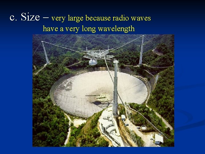 c. Size – very large because radio waves have a very long wavelength 