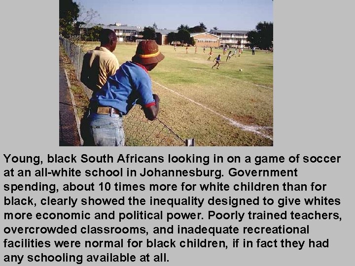 Young, black South Africans looking in on a game of soccer at an all-white