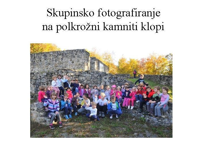 Skupinsko fotografiranje na polkrožni kamniti klopi 