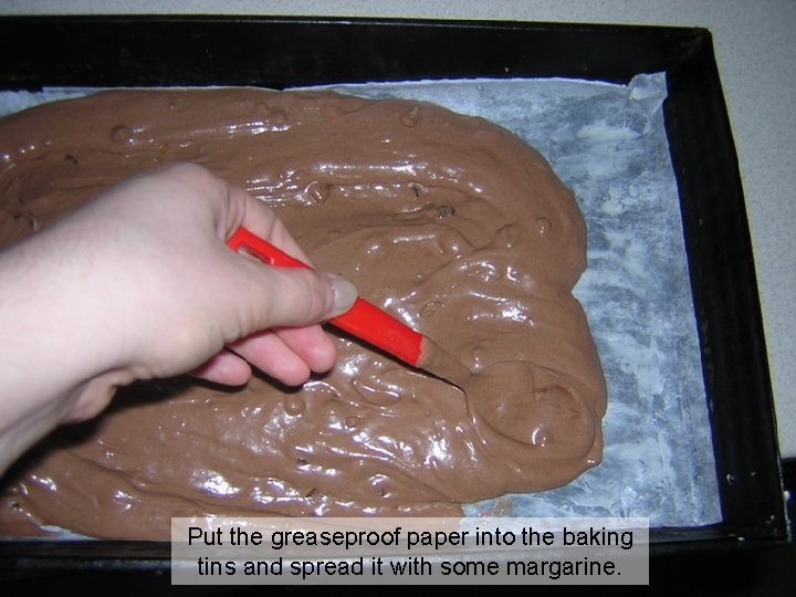Put the greaseproof paper into the baking tins and spread it with some margarine.