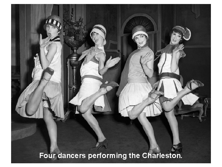 Four dancers performing the Charleston. 
