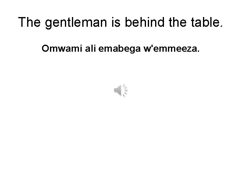 The gentleman is behind the table. Omwami ali emabega w'emmeeza. 