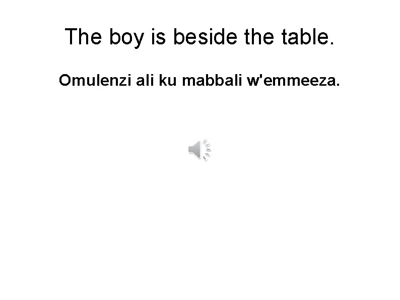The boy is beside the table. Omulenzi ali ku mabbali w'emmeeza. 