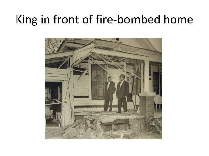 King in front of fire-bombed home 