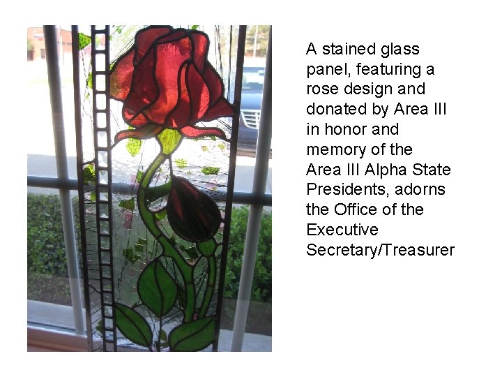 A stained glass panel, featuring a rose design and donated by Area III in