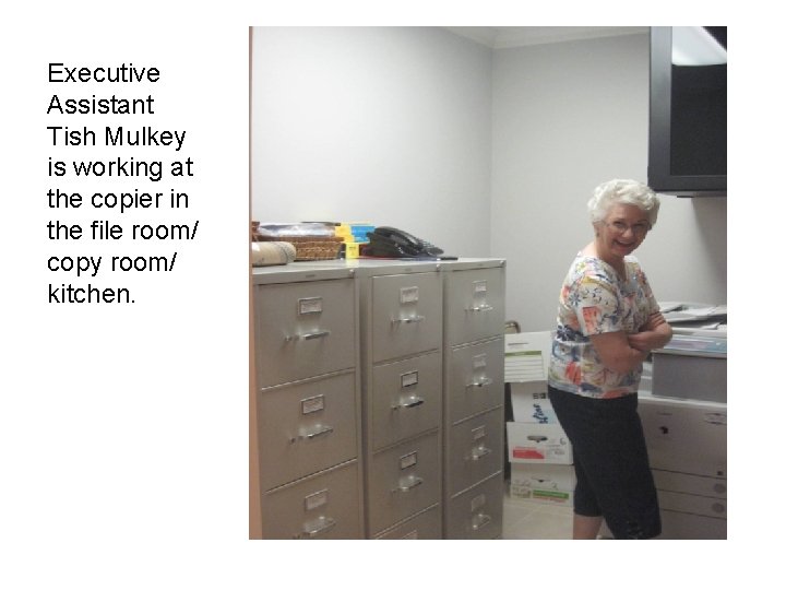 Executive Assistant Tish Mulkey is working at the copier in the file room/ copy