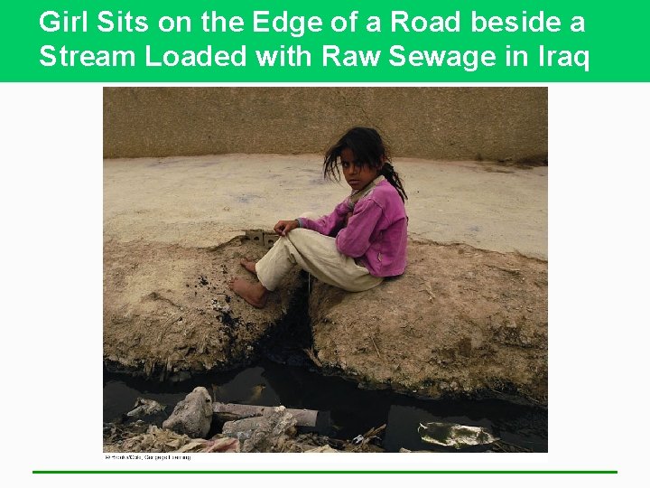 Girl Sits on the Edge of a Road beside a Stream Loaded with Raw