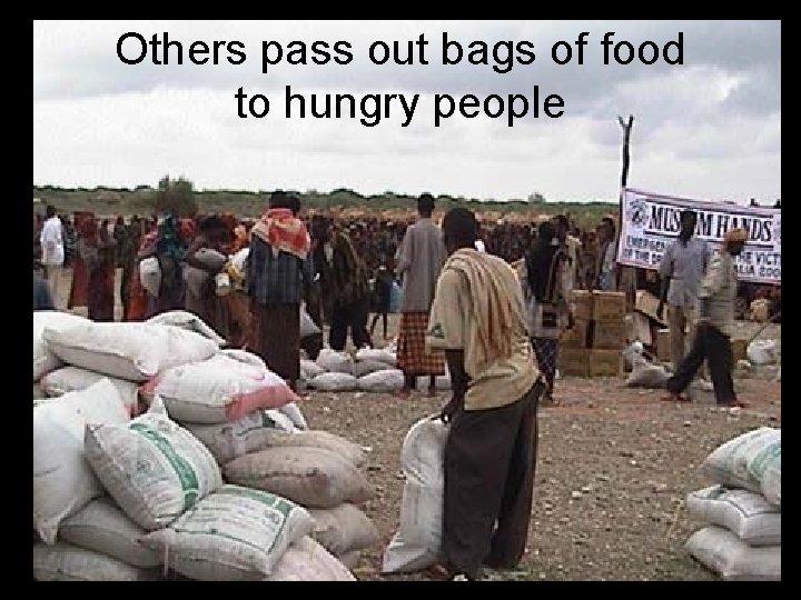 Others pass out bags of food to hungry people 