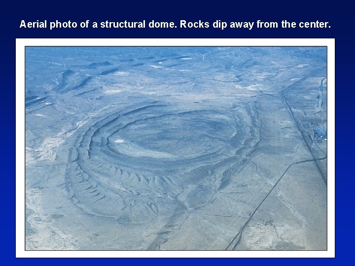 Aerial photo of a structural dome. Rocks dip away from the center. 