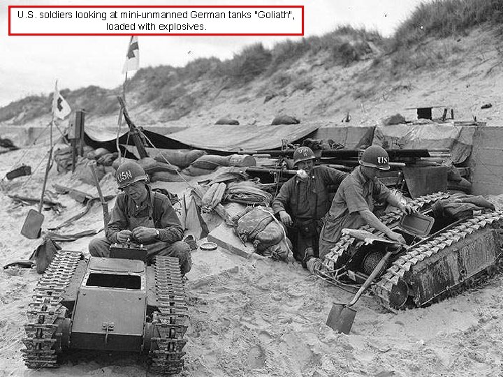 U. S. soldiers looking at mini-unmanned German tanks "Goliath", loaded with explosives. 