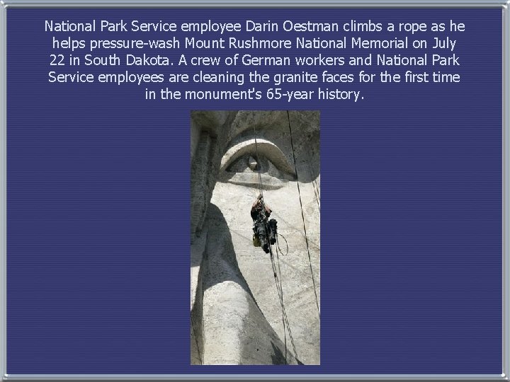 National Park Service employee Darin Oestman climbs a rope as he helps pressure-wash Mount