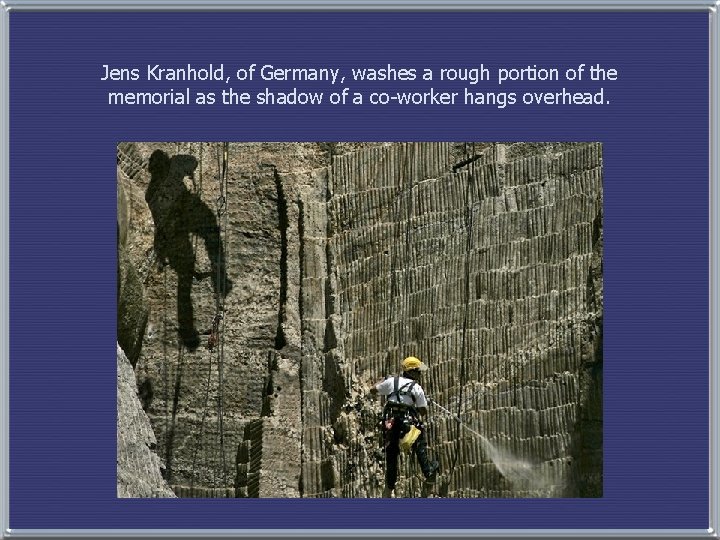 Jens Kranhold, of Germany, washes a rough portion of the memorial as the shadow
