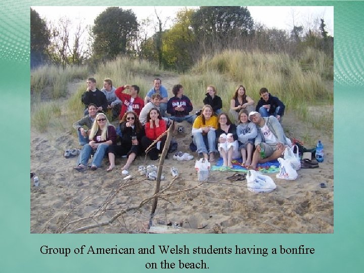 Group of American and Welsh students having a bonfire on the beach. 