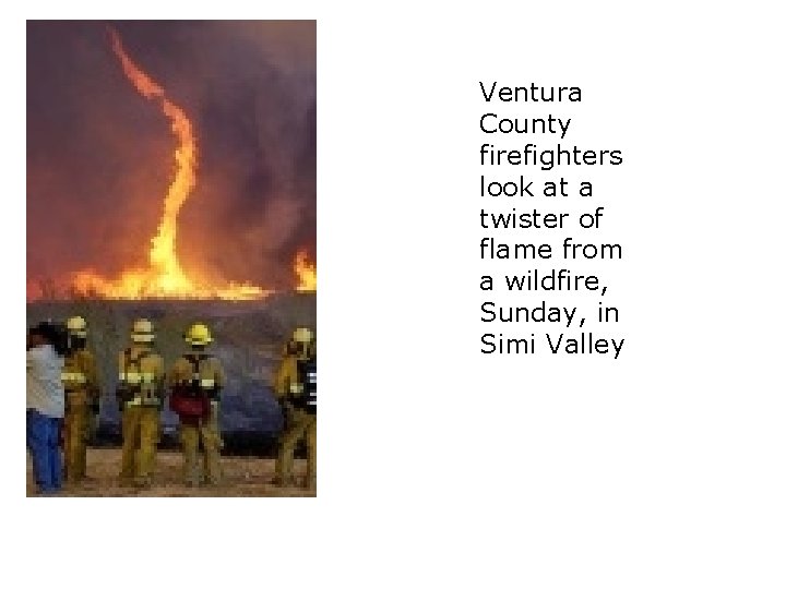 Ventura County firefighters look at a twister of flame from a wildfire, Sunday, in