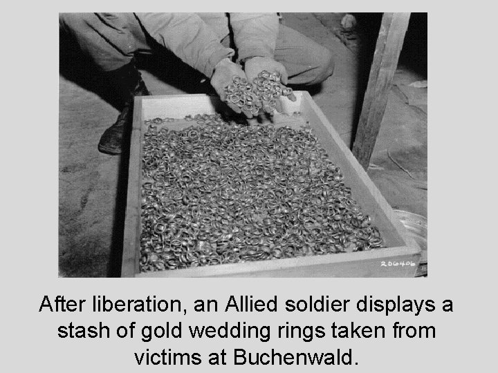 After liberation, an Allied soldier displays a stash of gold wedding rings taken from